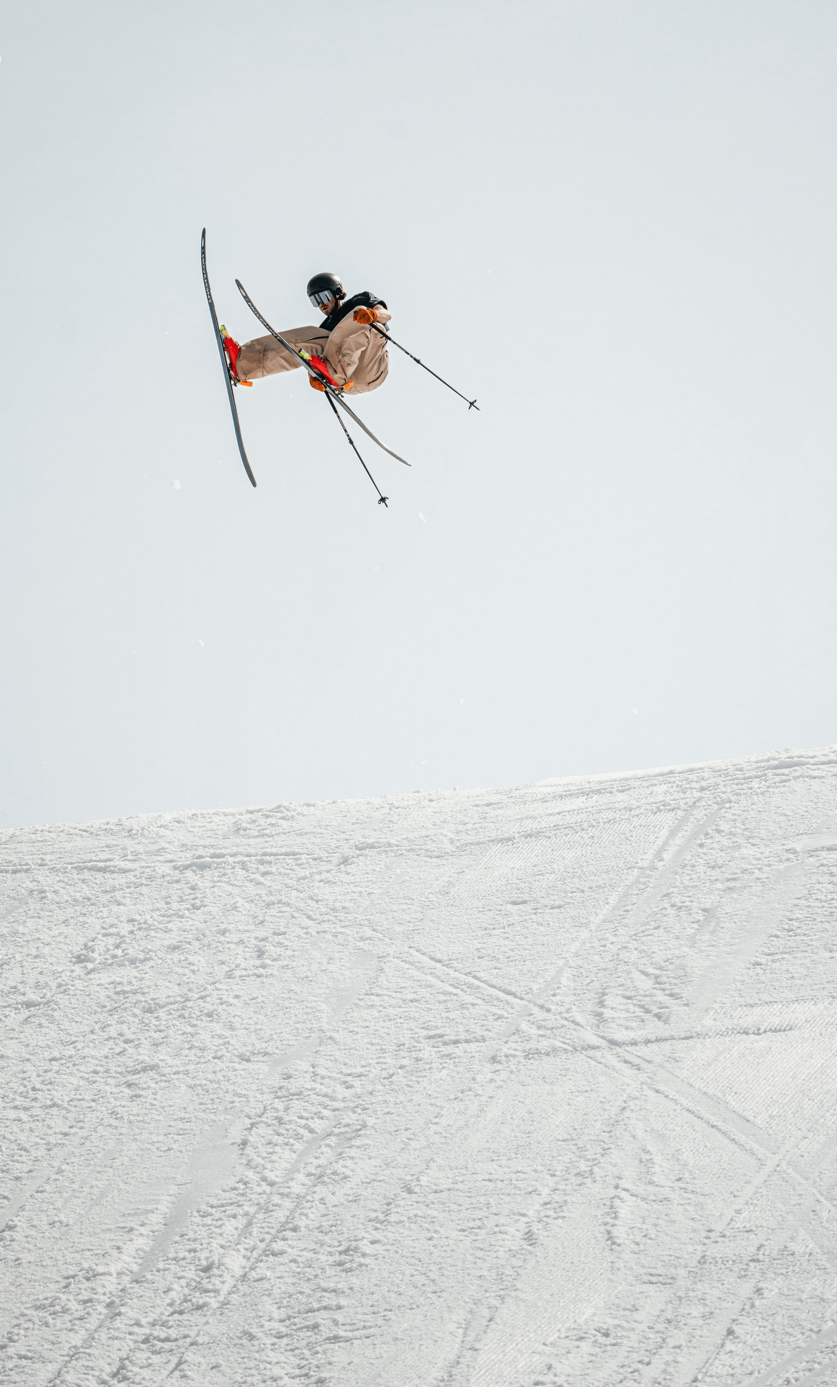 A man jumping with his skis while doing freestyle skiing